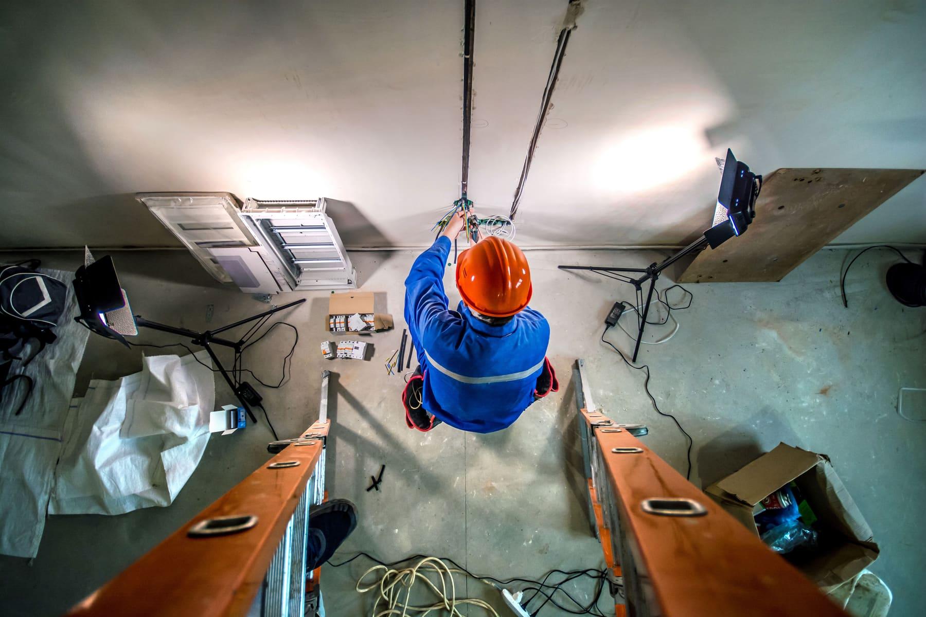 Electrician working overhead on a job site